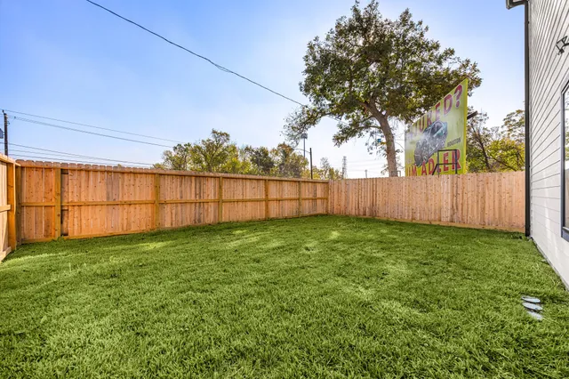 a view of backyard with wooden fence