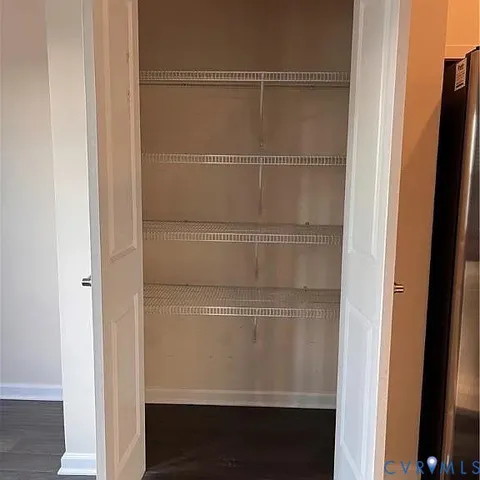 a kitchen with stainless steel appliances a refrigerator and wooden floors