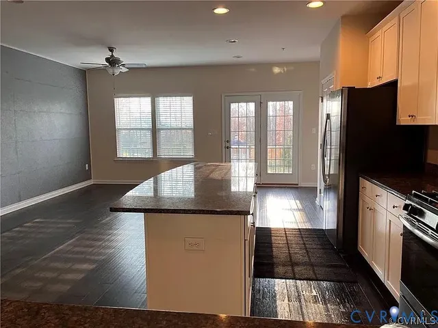 a kitchen with stainless steel appliances granite countertop a sink a stove and cabinets