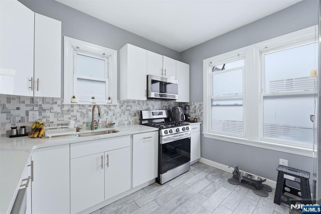 757 Thomas Street Elizabeth, NJ 07202 - Photo 7 of 38 a kitchen with stainless steel appliances granite countertop a stove a sink and a microwave