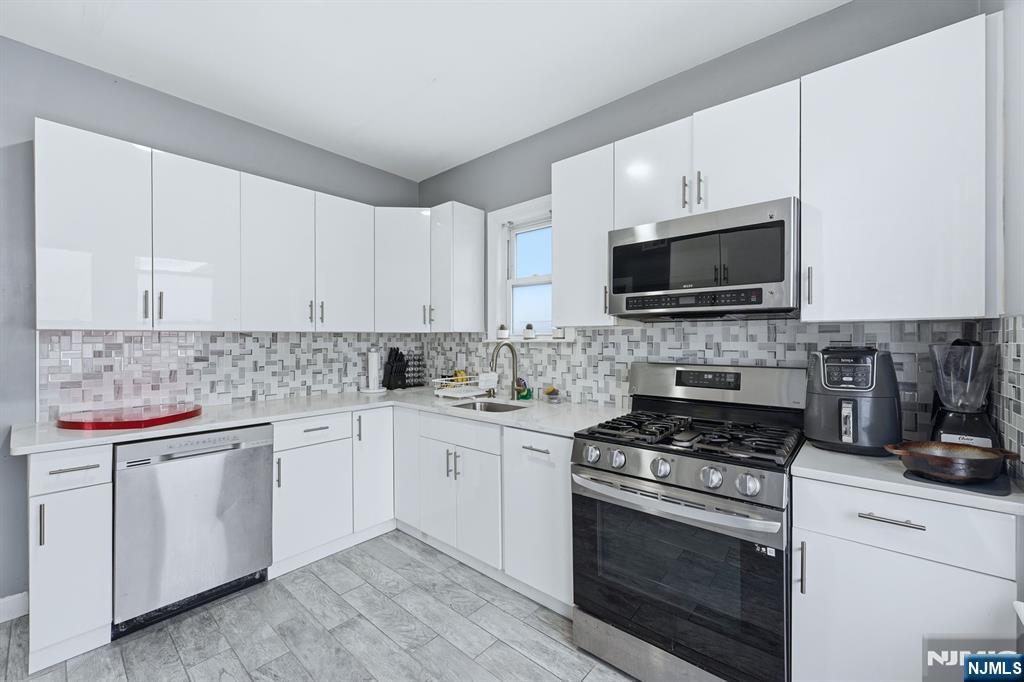 757 Thomas Street Elizabeth, NJ 07202 - Photo 8 of 38 a kitchen with cabinets stainless steel appliances and a sink