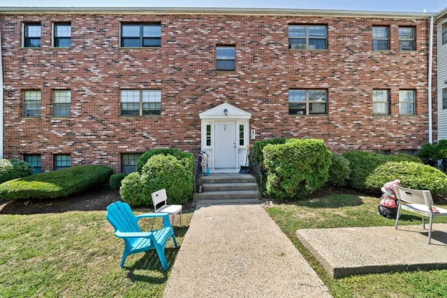 a front view of a house with garden and plants