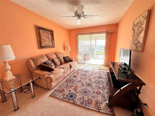 a living room with furniture and a floor to ceiling window