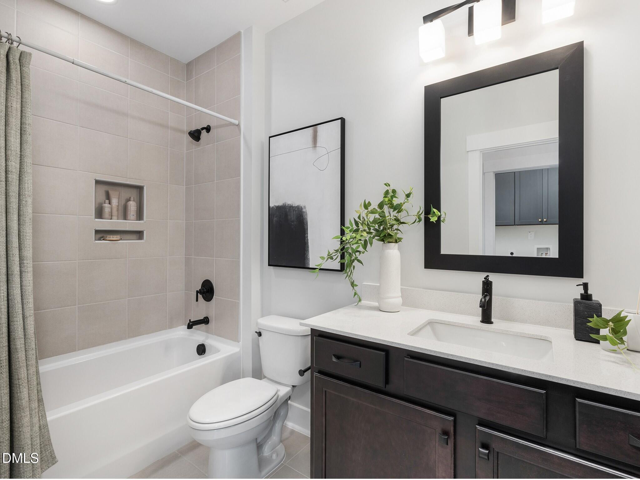 612 Cable Court Apex, NC 27523 - Photo 4 of 12 a bathroom with a sink toilet a mirror a vanity and shower