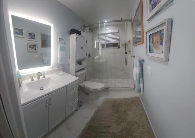 a bathroom with a sink a toilet and shower