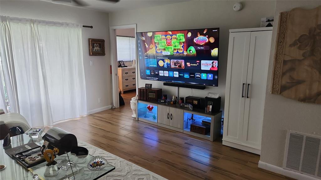 2202 Northeast 36th Street, Unit 15 Lighthouse Point, FL 33064 - Photo 12 of 47 a living room with furniture a flat screen tv and a refrigerator