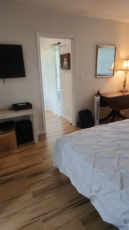 2202 Northeast 36th Street, Unit 15 Lighthouse Point, FL 33064 - Photo 25 of 47 a bedroom with a bed and a flat screen tv