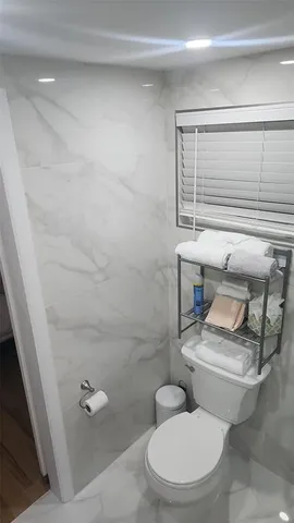 a white toilet sitting next to a bathroom sink