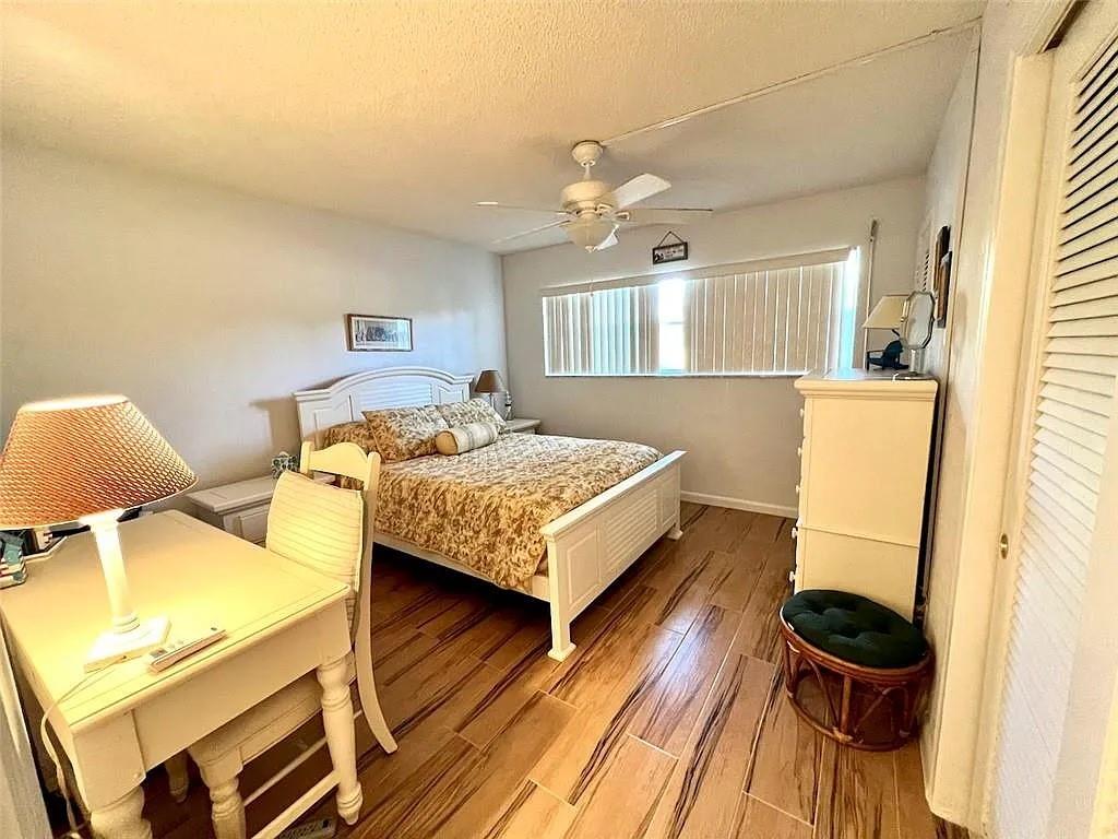 2202 Northeast 36th Street, Unit 15 Lighthouse Point, FL 33064 - Photo 37 of 47 a bedroom with a bed and a table in it
