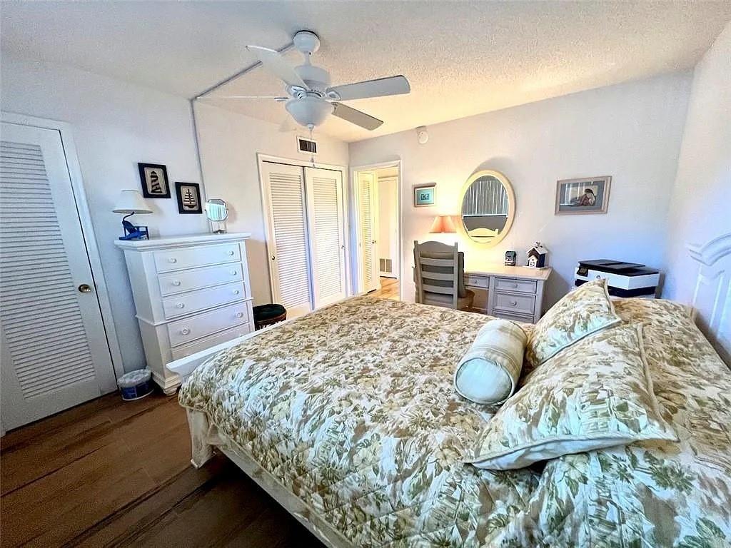 2202 Northeast 36th Street, Unit 15 Lighthouse Point, FL 33064 - Photo 38 of 47 a bedroom with a bed and wooden floor