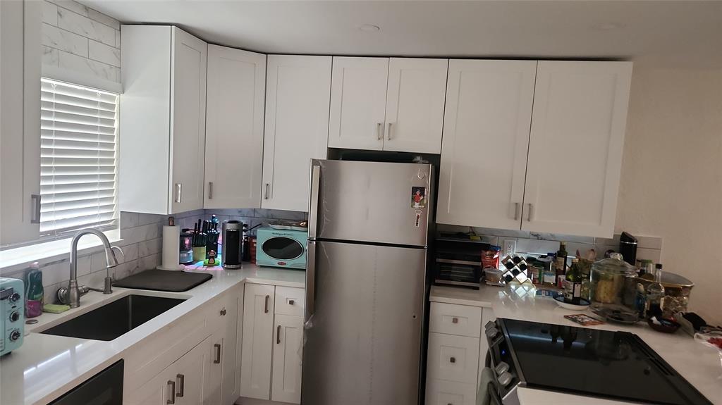 2202 Northeast 36th Street, Unit 15 Lighthouse Point, FL 33064 - Photo 5 of 47 a kitchen with a refrigerator and a sink