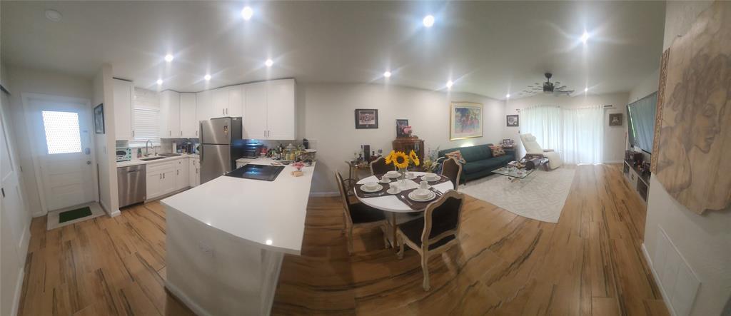 2202 Northeast 36th Street, Unit 15 Lighthouse Point, FL 33064 - Photo 9 of 47 a kitchen with stainless steel appliances kitchen island granite countertop a refrigerator a stove a sink a dining table and chairs with wooden floor