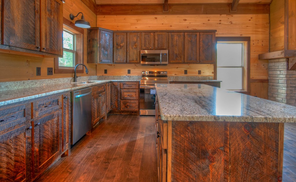 57 Devin Drive Murphy, NC 28906 - Photo 5 of 36 a kitchen with stainless steel appliances granite countertop a stove a sink dishwasher and a microwave oven with wooden cabinets