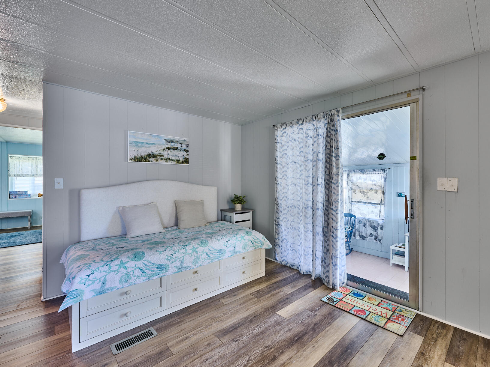 6977 Southeast Delegate Street Hobe Sound, FL 33455 - Photo 12 of 60 a bedroom with a large bed and a chandelier
