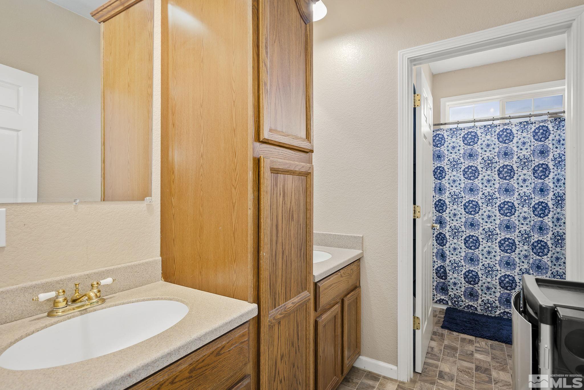 8650 Wise Reno, NV 89506 - Photo 15 of 25 a bathroom with a granite countertop sink a mirror and a shower