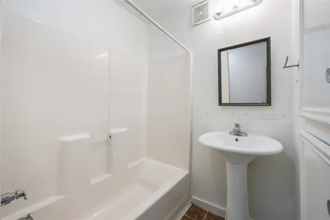 a bathroom with a sink a mirror and a bathtub