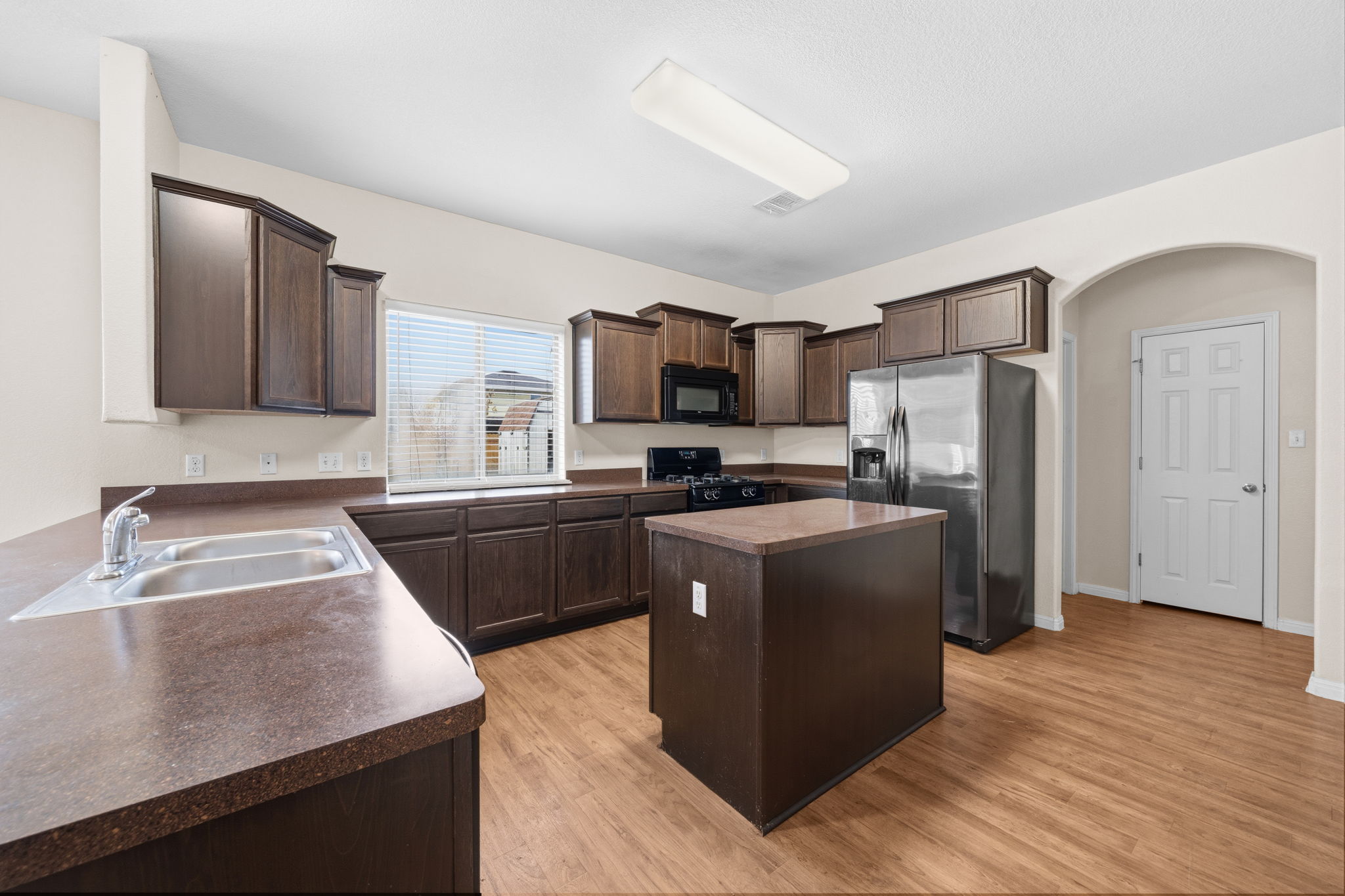 601 Silver Wing Drive Austin, TX 78725 - Photo 3 of 15 a kitchen with granite countertop a refrigerator and a sink