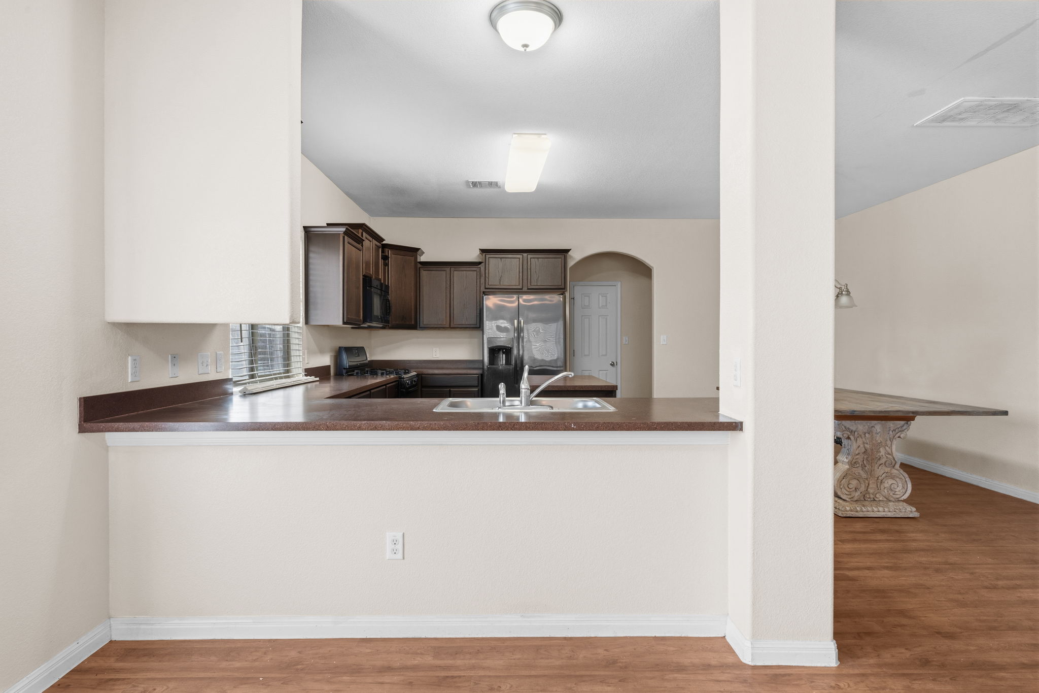 601 Silver Wing Drive Austin, TX 78725 - Photo 4 of 15 a view of a kitchen with kitchen island a sink wooden floor and counter top space