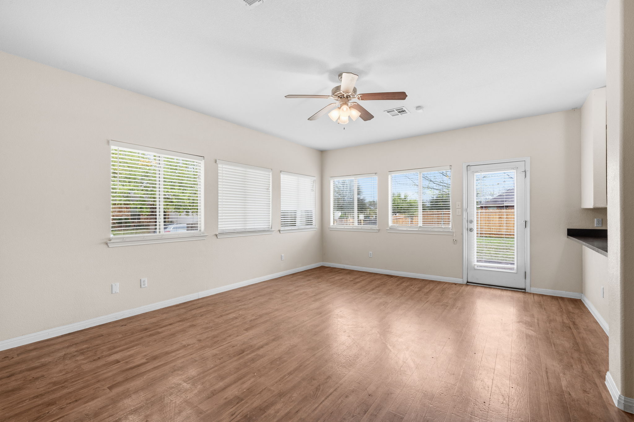 601 Silver Wing Drive Austin, TX 78725 - Photo 6 of 15 a view of an empty room with wooden floor and a window