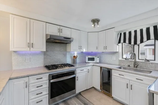 a kitchen with white cabinets and appliances