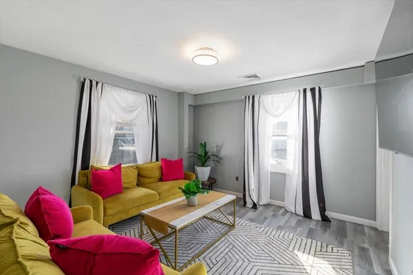 a living room with furniture and a potted plant