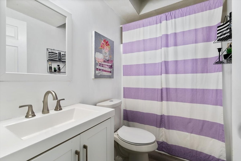 11 Andover Street Danvers, MA 01923 - Photo 29 of 41 a bathroom with a sink and mirror with toilet