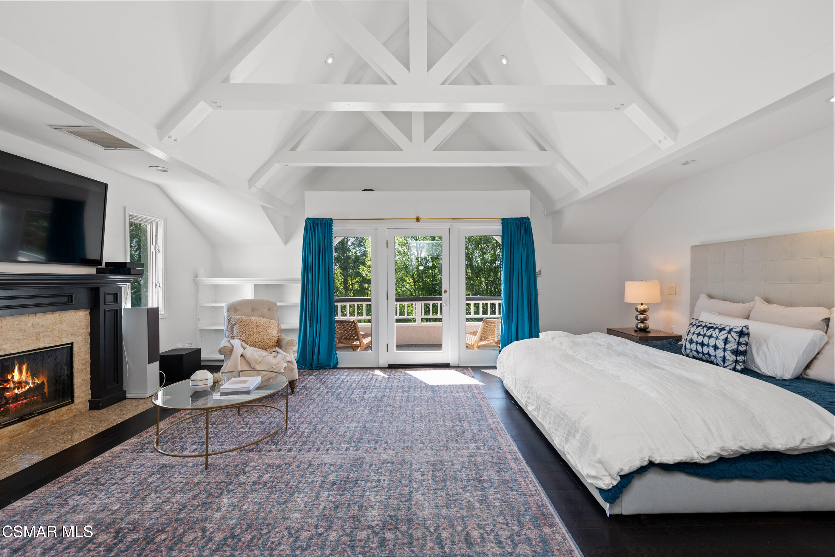 6144 Chesebro Road Agoura Hills, CA 91301 - Photo 28 of 73 a spacious bedroom with a large bed a flat tv screen and a fireplace with the potted plant