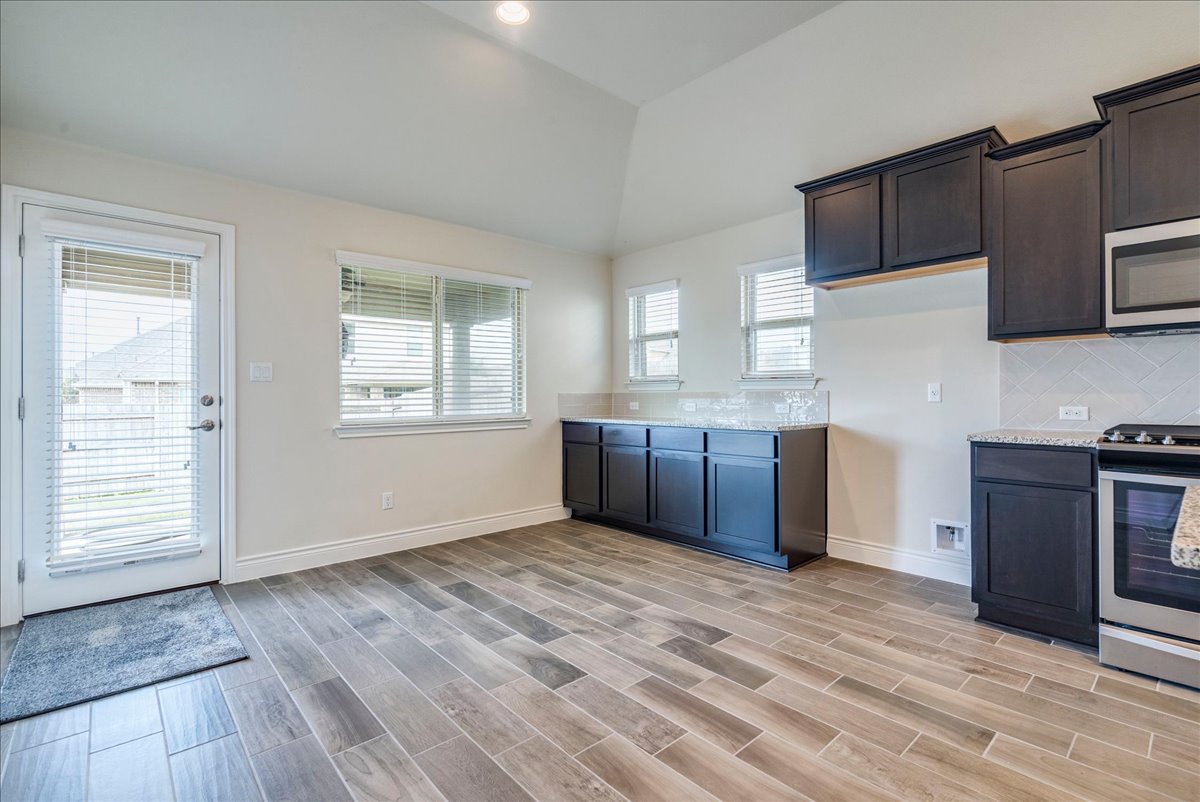124 Compass Lane Kyle, TX 78640 - Photo 13 of 38 a kitchen with stainless steel appliances granite countertop a refrigerator and a stove top oven