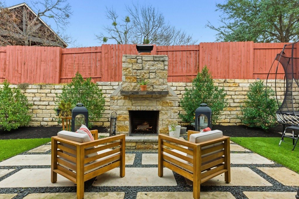 5425 Cherokee Draw Road Austin, TX 78738 - Photo 36 of 40 An inviting stone fireplace anchors this private outdoor seating area, perfect for tranquil evenings.