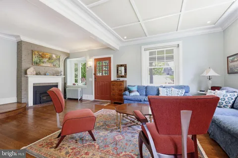 a living room with furniture a fireplace and wooden floor