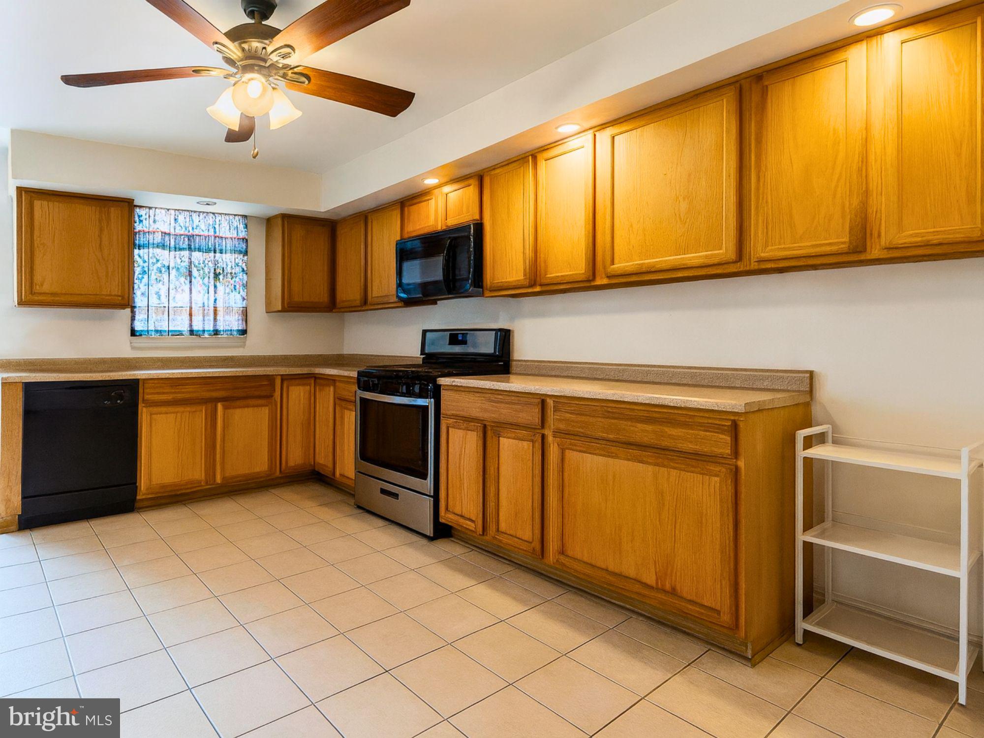 2715 East Madison Street Baltimore, MD 21205 - Photo 3 of 11 a kitchen with stainless steel appliances granite countertop a sink cabinets and window