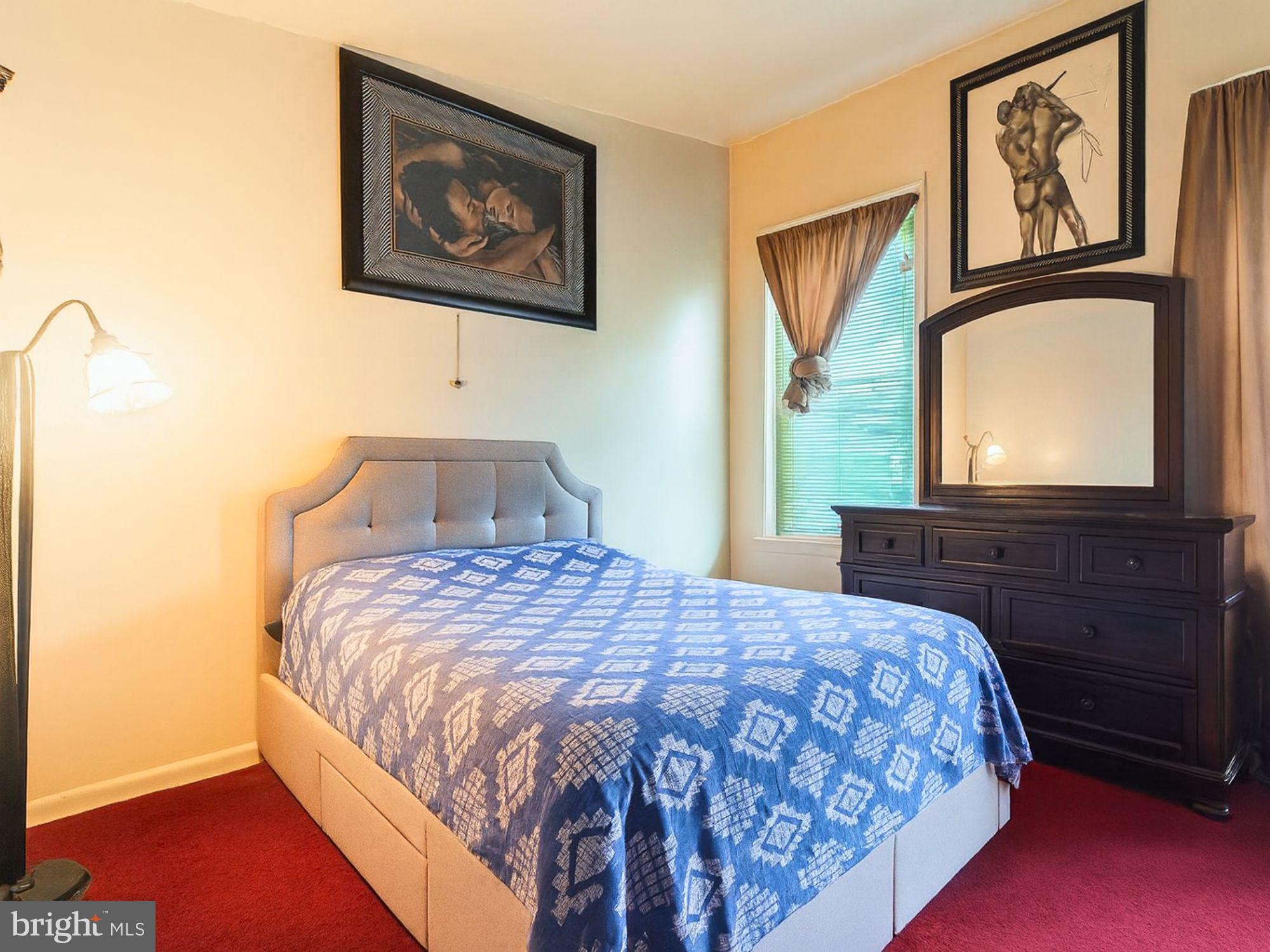 2715 East Madison Street Baltimore, MD 21205 - Photo 6 of 11 a bedroom with a bed and a flat screen tv