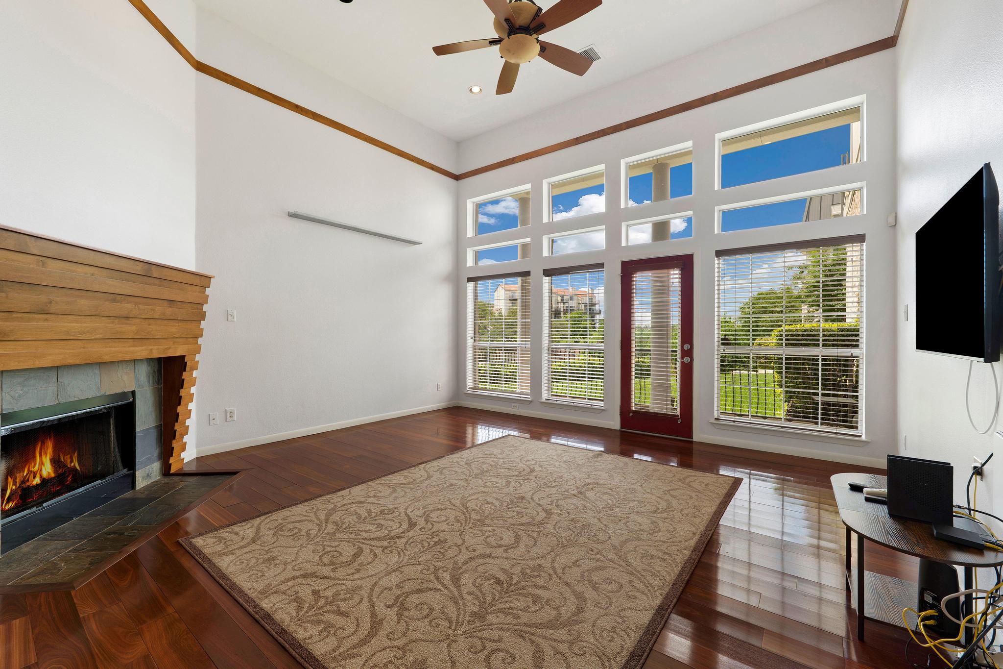 2918 Ranch Road 620, Unit J162 Austin, TX 78734 - Photo 10 of 26 Living area with a vaulted ceiling, wood-finish flooring, and a fireplace with a wood mantel