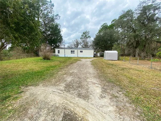 a view of a house with a yard and sitting area