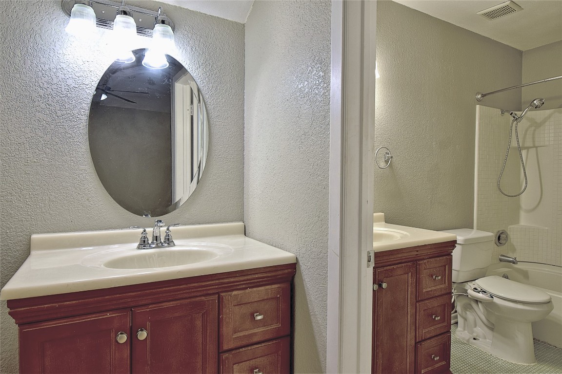 7635 Guadalupe Street, Unit 803 Austin, TX 78752 - Photo 12 of 16 a bathroom with a toilet a sink and mirror