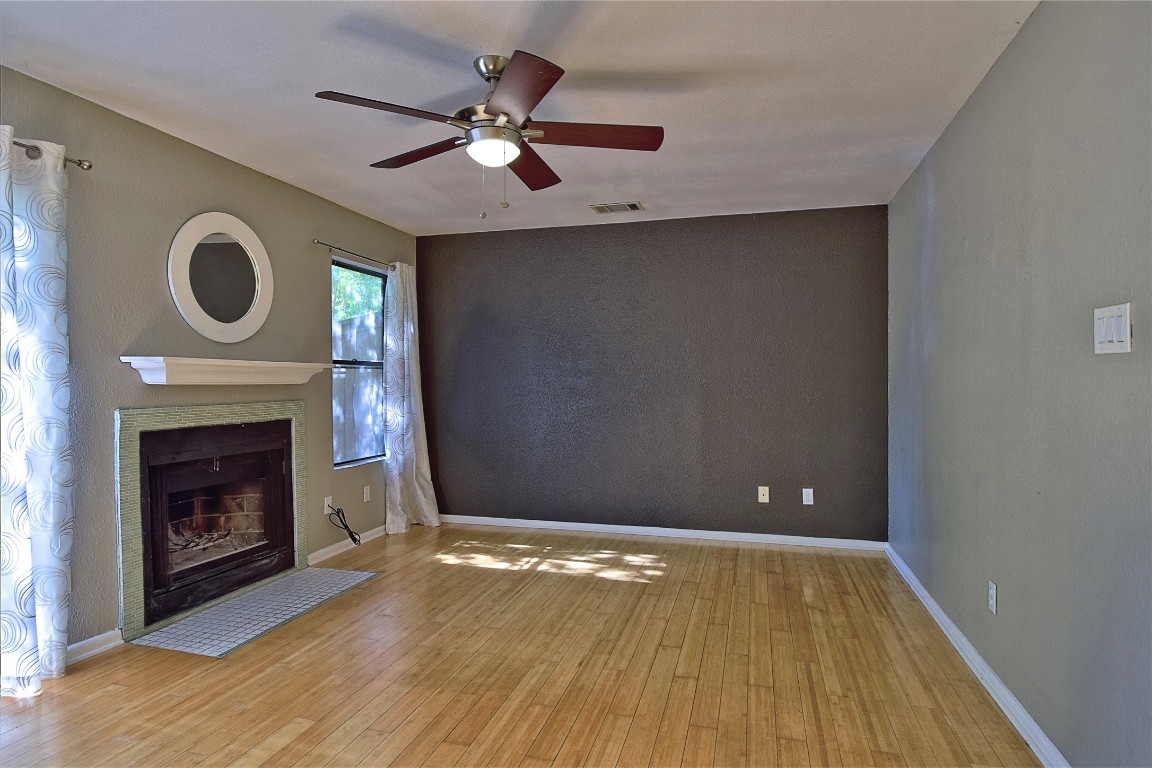 7635 Guadalupe Street, Unit 803 Austin, TX 78752 - Photo 3 of 16 a view of an empty room with wooden floor and a fireplace