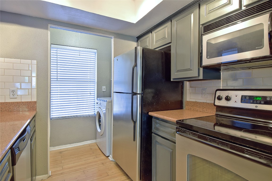 7635 Guadalupe Street, Unit 803 Austin, TX 78752 - Photo 6 of 16 a kitchen with stainless steel appliances granite countertop a refrigerator and a stove