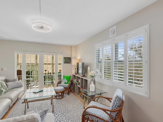 a living room with furniture and floor to ceiling windows