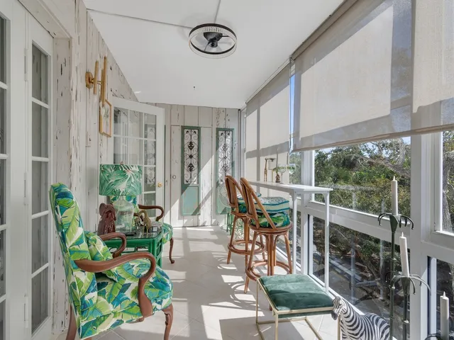 a view of a porch with chairs and potted plants