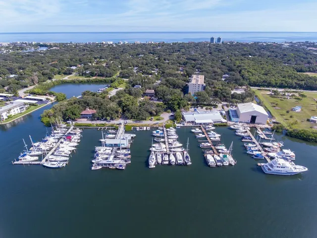 an aerial view of a tennis ground and a cars park side of the road