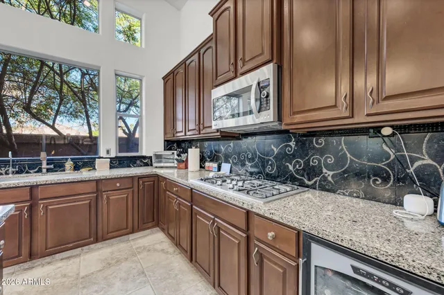a kitchen with kitchen island granite countertop a sink cabinets and stainless steel appliances