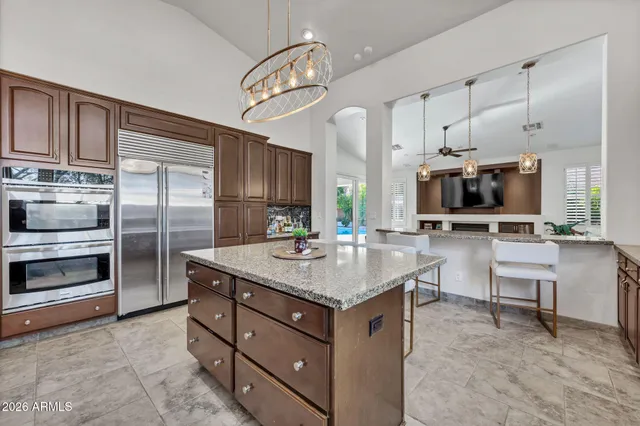 a kitchen with stainless steel appliances kitchen island granite countertop a refrigerator and a sink