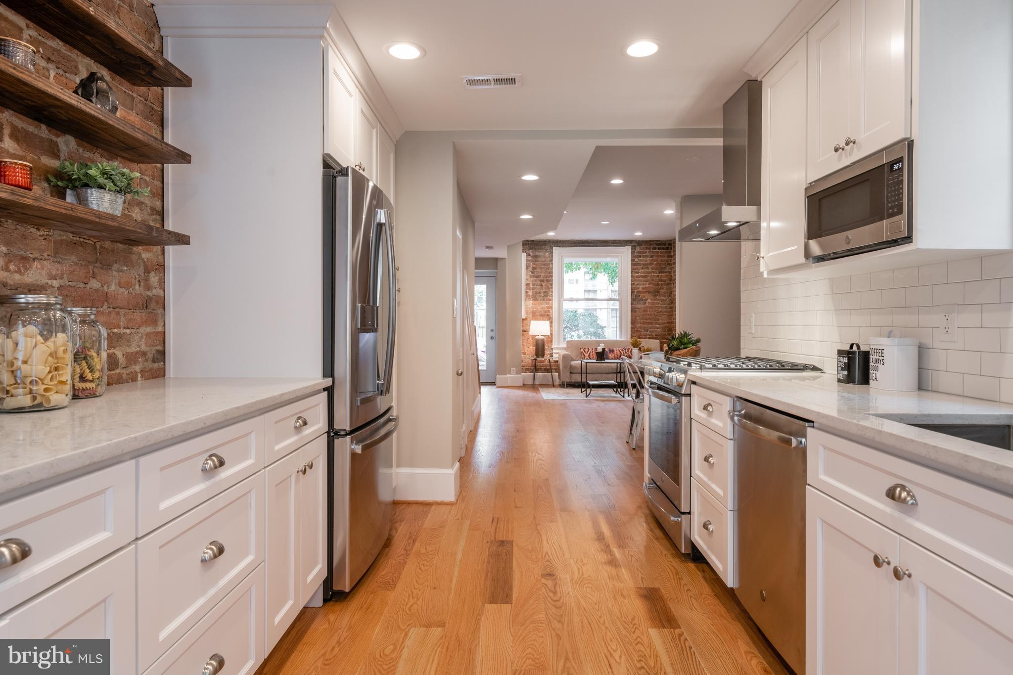 1327 V Street Northwest Washington, DC 20009 - Photo 12 of 29 a large kitchen with stainless steel appliances a lot of counter space and wooden floors
