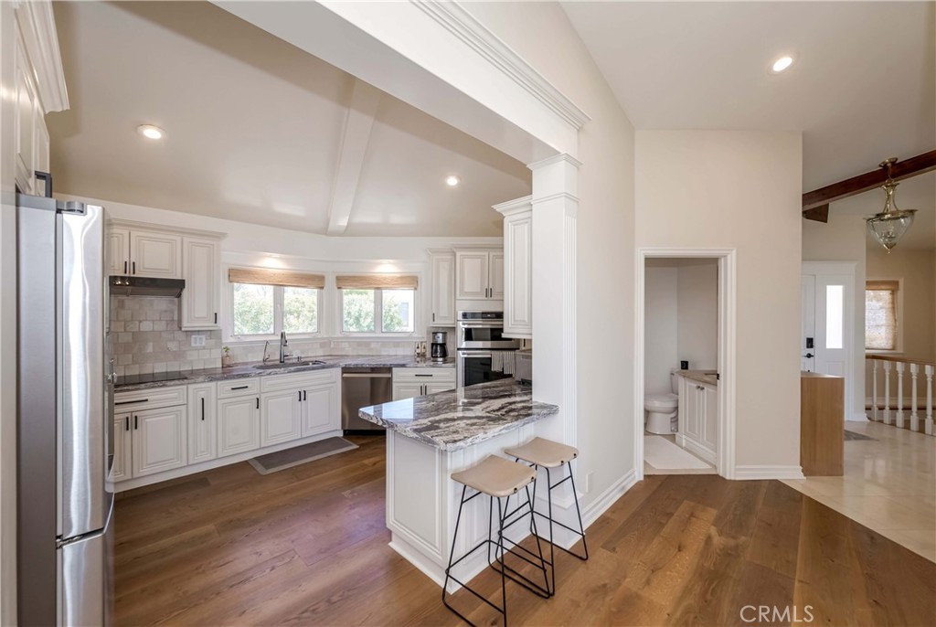1 Hackamore Road Rolling Hills, CA 90274 - Photo 35 of 57 a open kitchen with granite countertop a stove top oven a sink dishwasher and a refrigerator with wooden floor