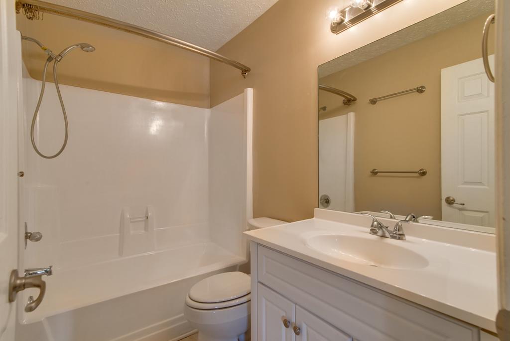 7810 Chester Road Fairview, TN 37062 - Photo 11 of 17 a bathroom with a granite countertop sink a toilet and shower
