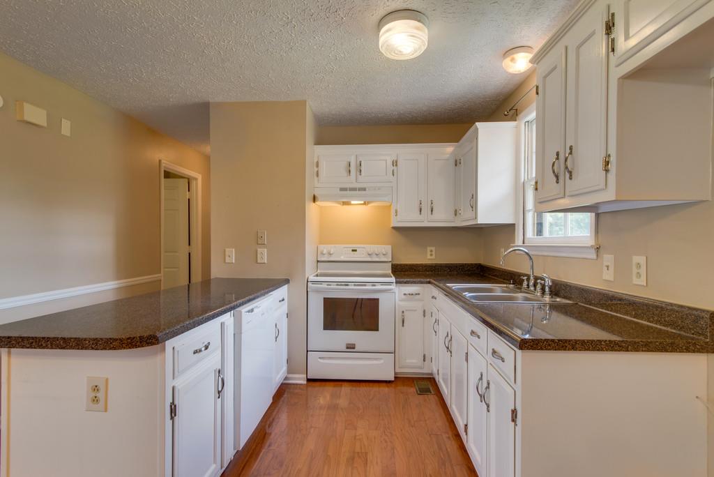 7810 Chester Road Fairview, TN 37062 - Photo 6 of 17 a kitchen with granite countertop a sink stove and cabinets
