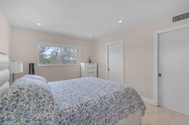 a bedroom with a large bed and a window