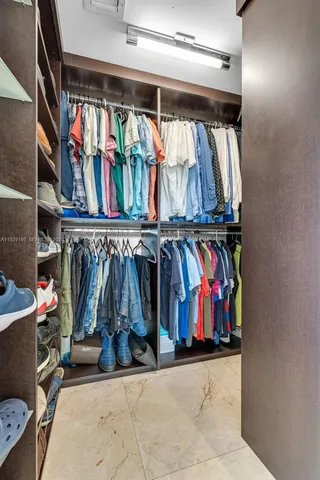 a view of walk in closet with clothes