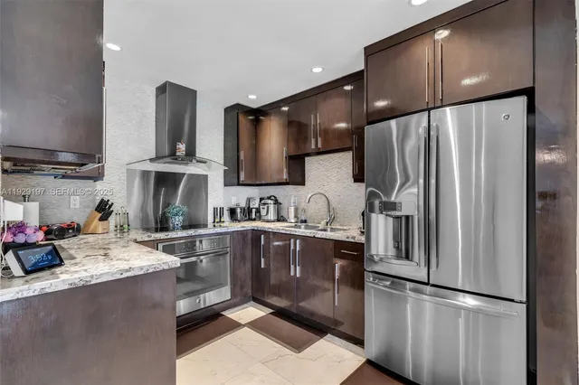 a kitchen with stainless steel appliances granite countertop a refrigerator sink and cabinets