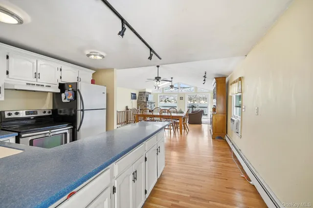 a kitchen with stainless steel appliances kitchen island granite countertop a stove a sink and a refrigerator